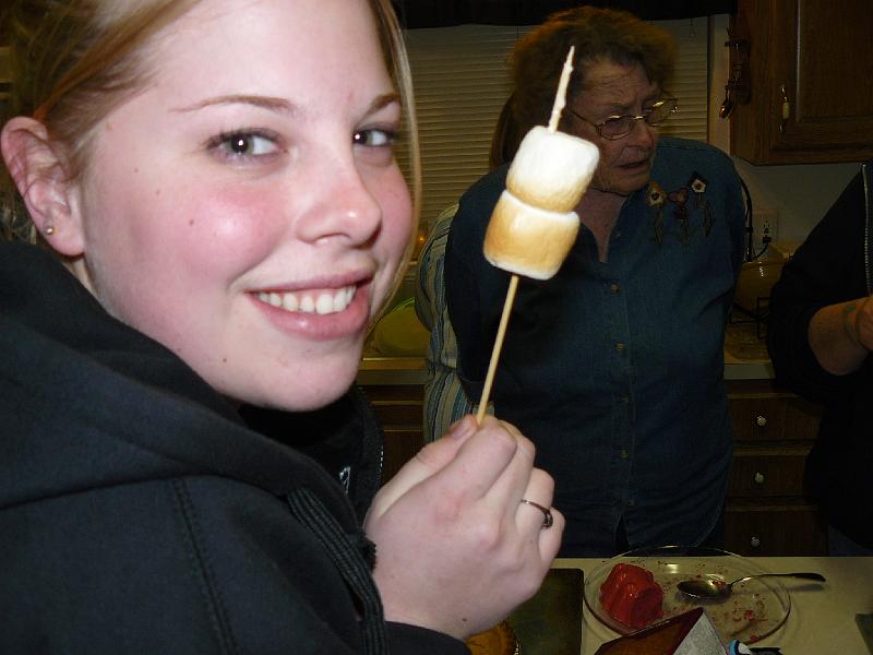 P1010145.JPG - Kristen shows off toasted marshmallows produced by a "toy" that Linda brought...